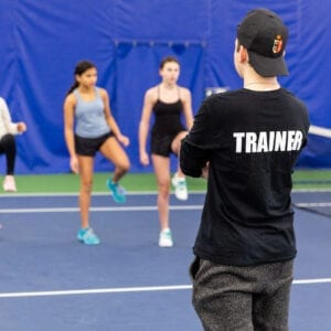A trainer standing and looking at students and helping train