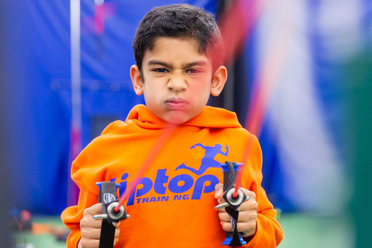 A small boy doing pulling exercise at an institute